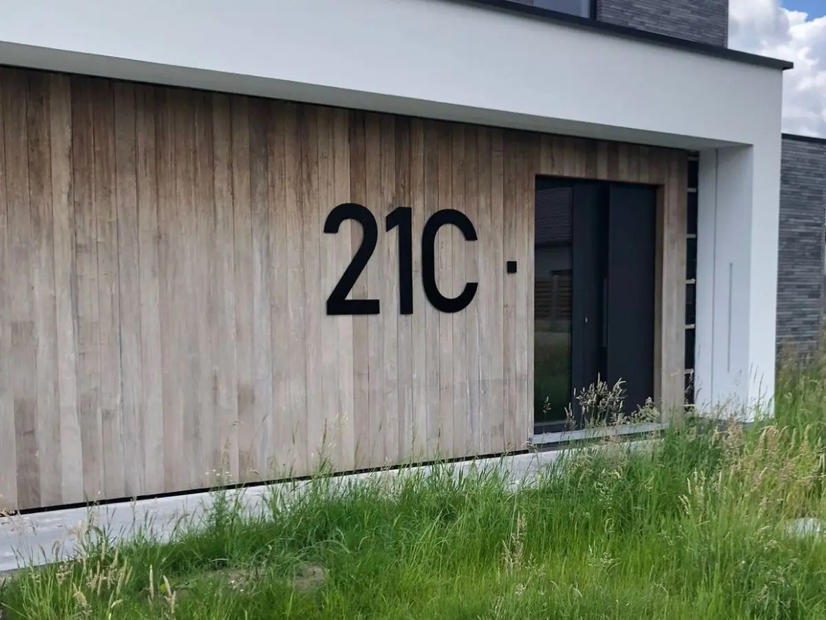 RVS huisnummer 21C van 100 cm hoog in zwart op een houten gevel van een moderne woning