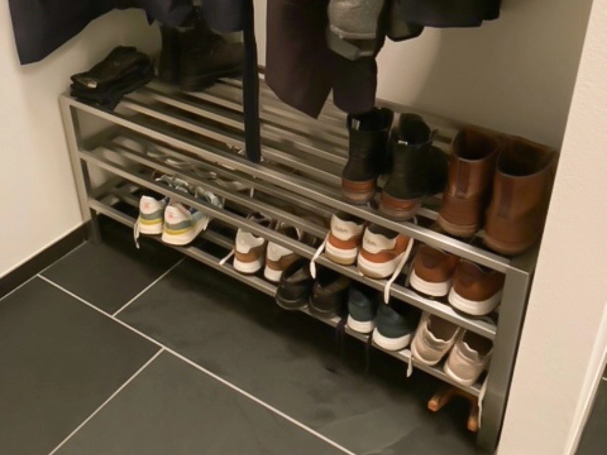 Brede uitvoering van een RVS schoenenrek, passend in een nis, volledig gevuld met schoenen