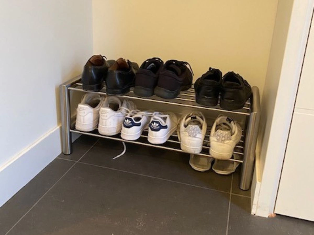 Compact op maat gemaakt RVS schoenenrek in een hal, geplaatst tegen een lichte muur